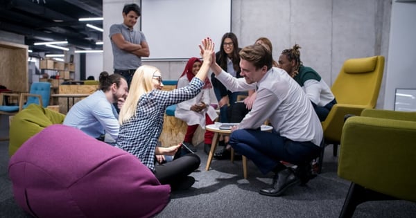 Equipo de trabajo festejando por la mejora de su rendimciento gracias a encuestas de employee experience